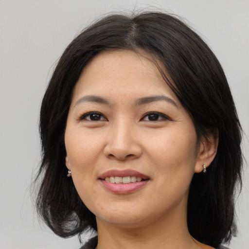 Joyful asian adult female with medium  brown hair and brown eyes