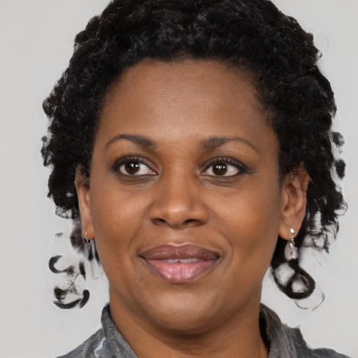 Joyful black adult female with medium  brown hair and brown eyes