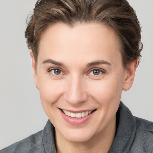 Joyful white young-adult female with short  brown hair and grey eyes