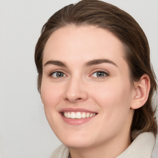 Joyful white young-adult female with medium  brown hair and grey eyes