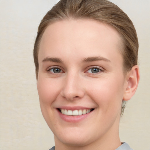 Joyful white young-adult female with short  brown hair and grey eyes