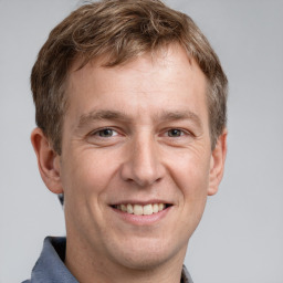 Joyful white adult male with short  brown hair and grey eyes