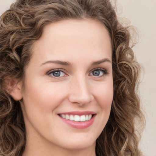 Joyful white young-adult female with long  brown hair and green eyes