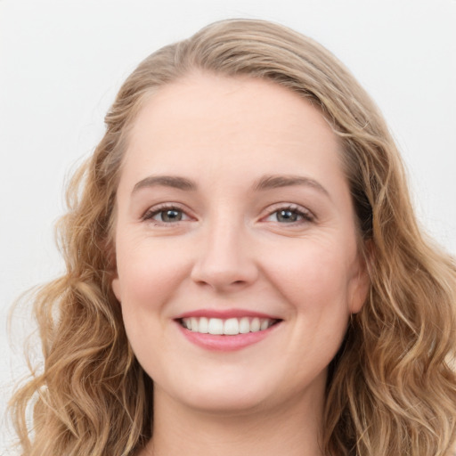 Joyful white young-adult female with long  brown hair and blue eyes