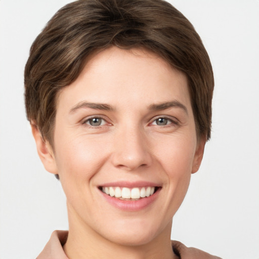 Joyful white young-adult female with short  brown hair and grey eyes