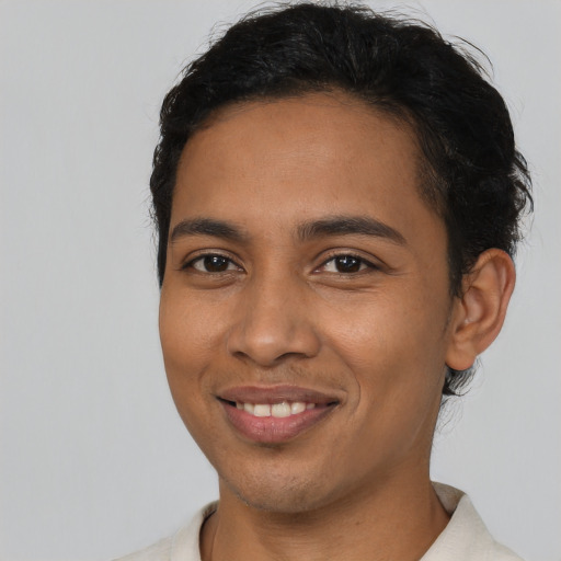 Joyful latino young-adult male with short  black hair and brown eyes