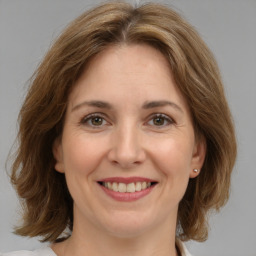 Joyful white adult female with medium  brown hair and grey eyes