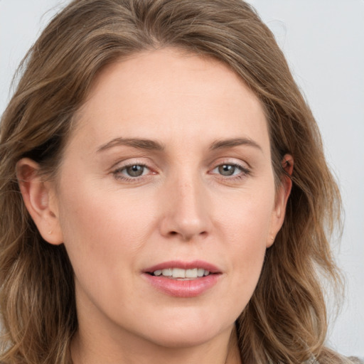 Joyful white young-adult female with long  brown hair and blue eyes