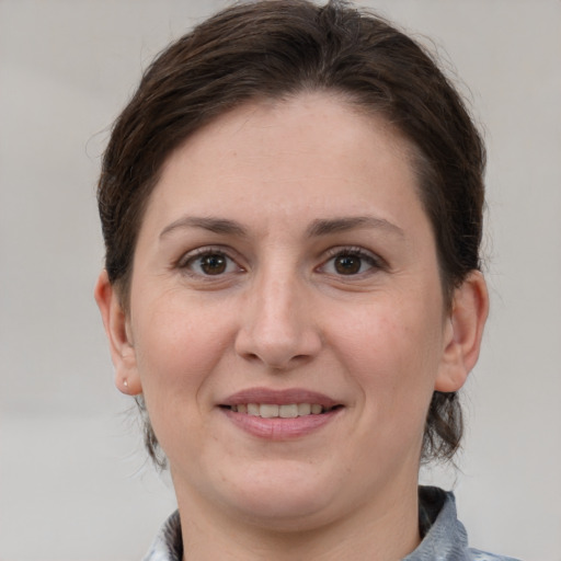 Joyful white adult female with medium  brown hair and grey eyes