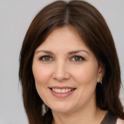 Joyful white adult female with medium  brown hair and brown eyes