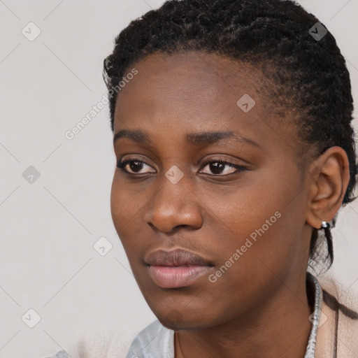 Joyful black young-adult female with short  black hair and brown eyes