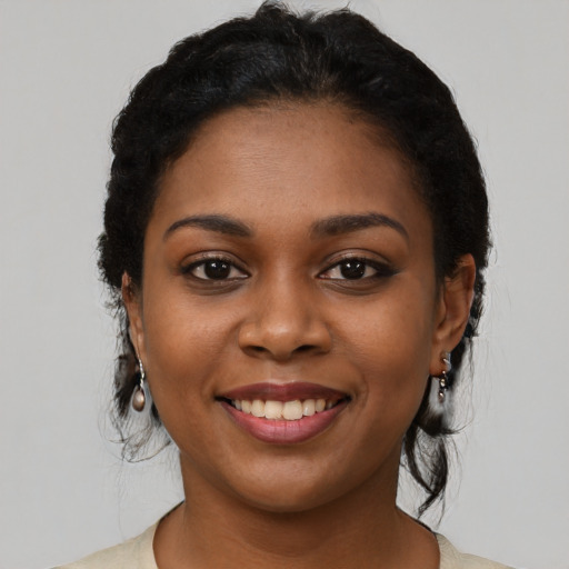 Joyful black young-adult female with short  black hair and brown eyes