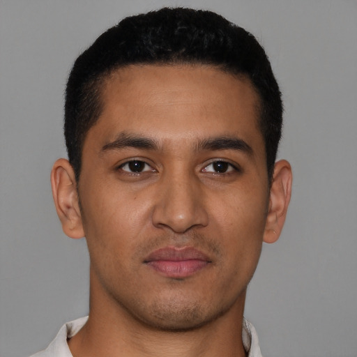 Joyful latino young-adult male with short  brown hair and brown eyes