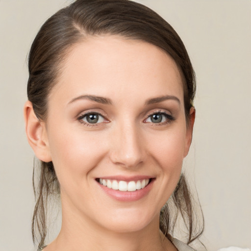 Joyful white young-adult female with medium  brown hair and grey eyes