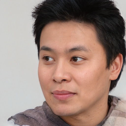Joyful asian young-adult male with short  brown hair and brown eyes