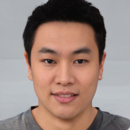 Joyful asian young-adult male with short  black hair and brown eyes