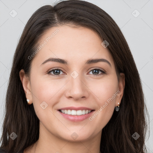 Joyful white young-adult female with long  brown hair and brown eyes