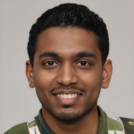 Joyful black young-adult male with short  black hair and brown eyes