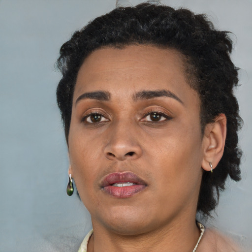 Joyful black young-adult female with short  brown hair and brown eyes