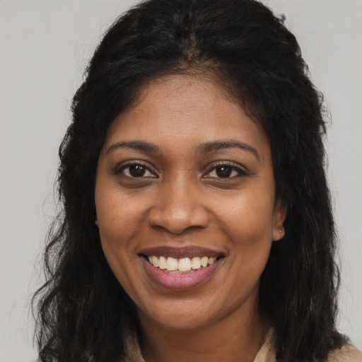 Joyful black young-adult female with long  brown hair and brown eyes