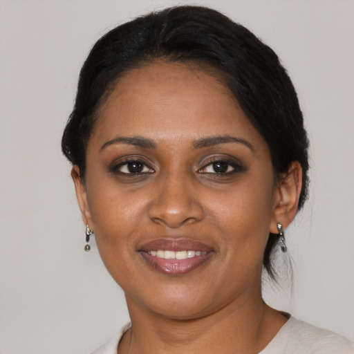 Joyful black young-adult female with short  black hair and brown eyes
