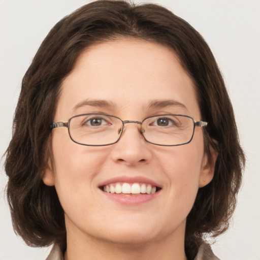 Joyful white adult female with medium  brown hair and green eyes