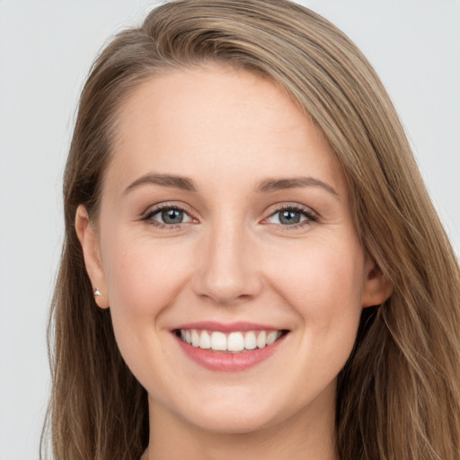 Joyful white young-adult female with long  brown hair and grey eyes