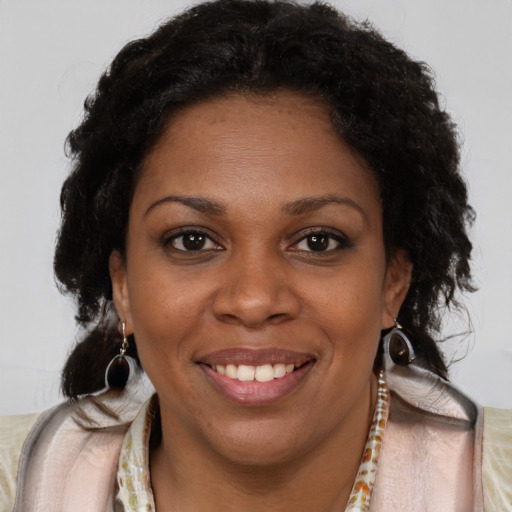 Joyful black young-adult female with long  brown hair and brown eyes