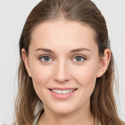 Joyful white young-adult female with long  brown hair and grey eyes