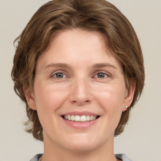 Joyful white young-adult female with medium  brown hair and grey eyes