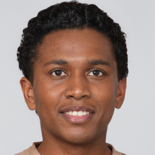 Joyful black young-adult male with short  brown hair and brown eyes