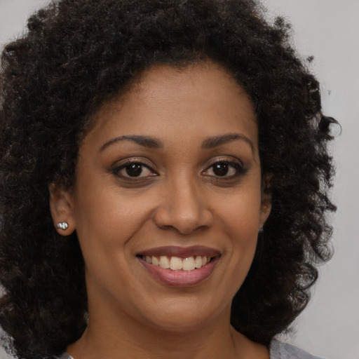 Joyful black young-adult female with medium  brown hair and brown eyes