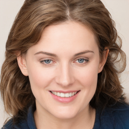 Joyful white young-adult female with medium  brown hair and blue eyes