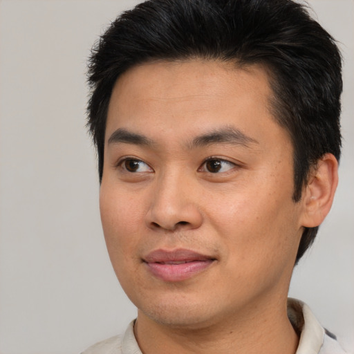 Joyful asian young-adult male with short  brown hair and brown eyes