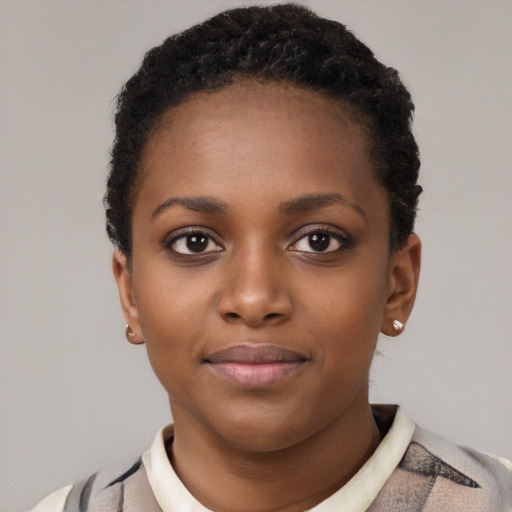 Joyful black young-adult female with short  black hair and brown eyes
