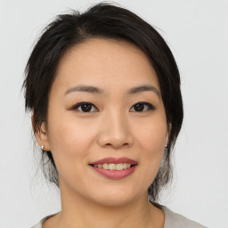 Joyful asian young-adult female with medium  black hair and brown eyes