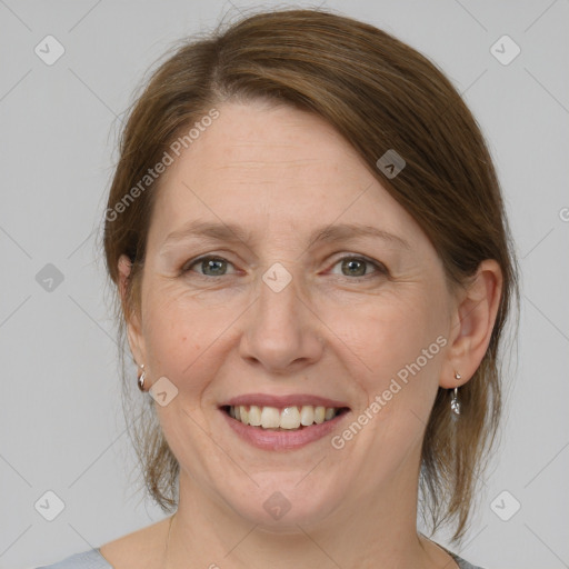 Joyful white adult female with medium  brown hair and grey eyes