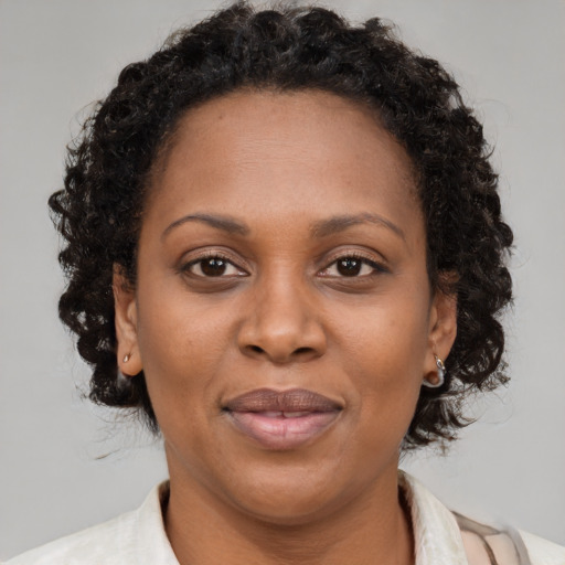 Joyful black adult female with medium  brown hair and brown eyes