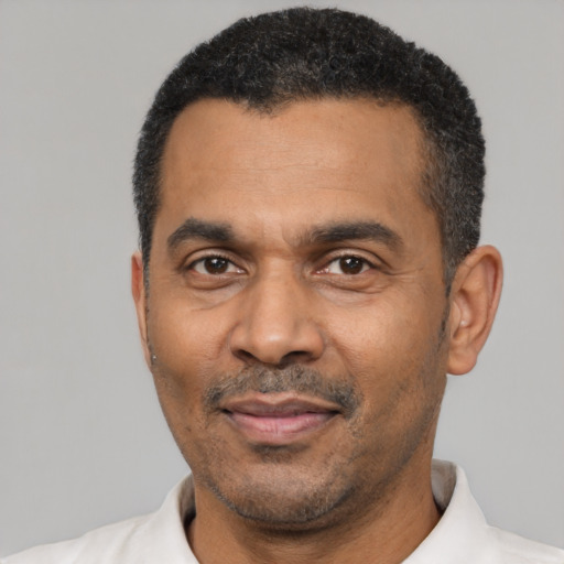 Joyful latino adult male with short  black hair and brown eyes