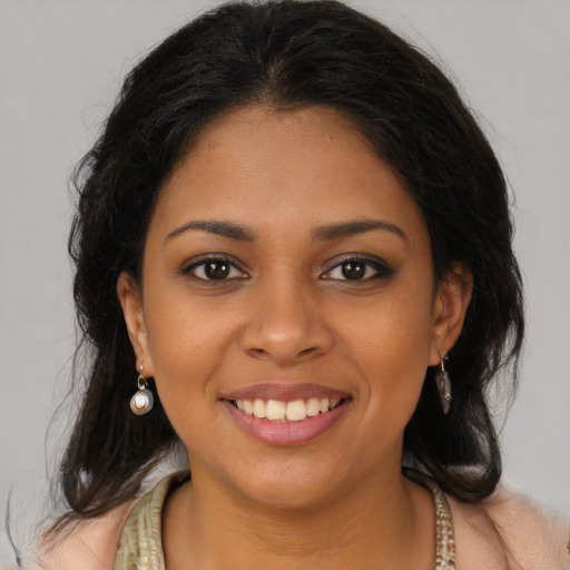 Joyful black young-adult female with long  brown hair and brown eyes