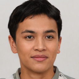 Joyful latino young-adult male with short  brown hair and brown eyes