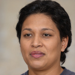 Joyful latino adult female with medium  brown hair and brown eyes