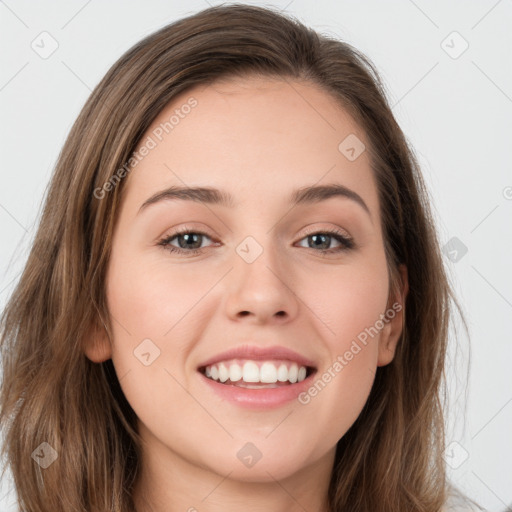 Joyful white young-adult female with long  brown hair and green eyes