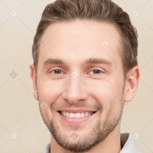 Joyful white young-adult male with short  brown hair and grey eyes