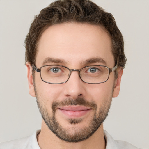 Joyful white young-adult male with short  brown hair and grey eyes