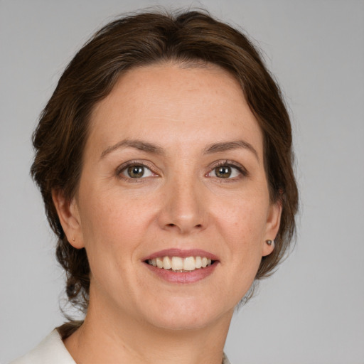 Joyful white adult female with medium  brown hair and grey eyes