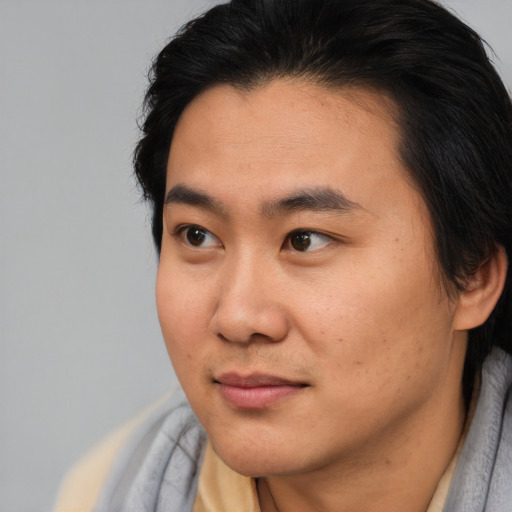 Joyful asian young-adult male with short  brown hair and brown eyes