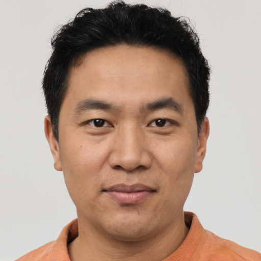 Joyful asian adult male with short  black hair and brown eyes