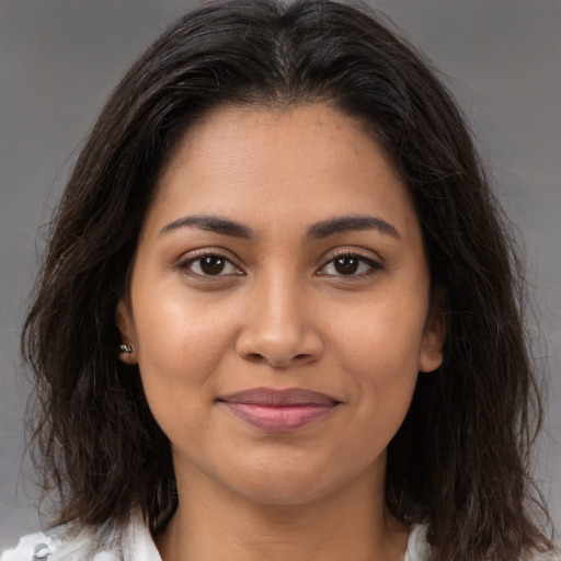 Joyful latino young-adult female with long  brown hair and brown eyes
