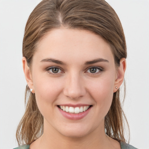 Joyful white young-adult female with medium  brown hair and grey eyes